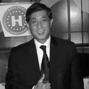 Black-and-white event portrait of Antonio Lau wearing a suit and tie.