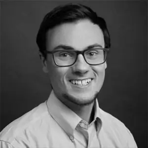 Black-and-white headshot of Bryan Rossmanith wearing glasses and a light collared shirt.