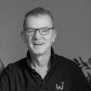 Black-and-white professional portrait of Guido Simonetti wearing glasses and a dark polo shirt.